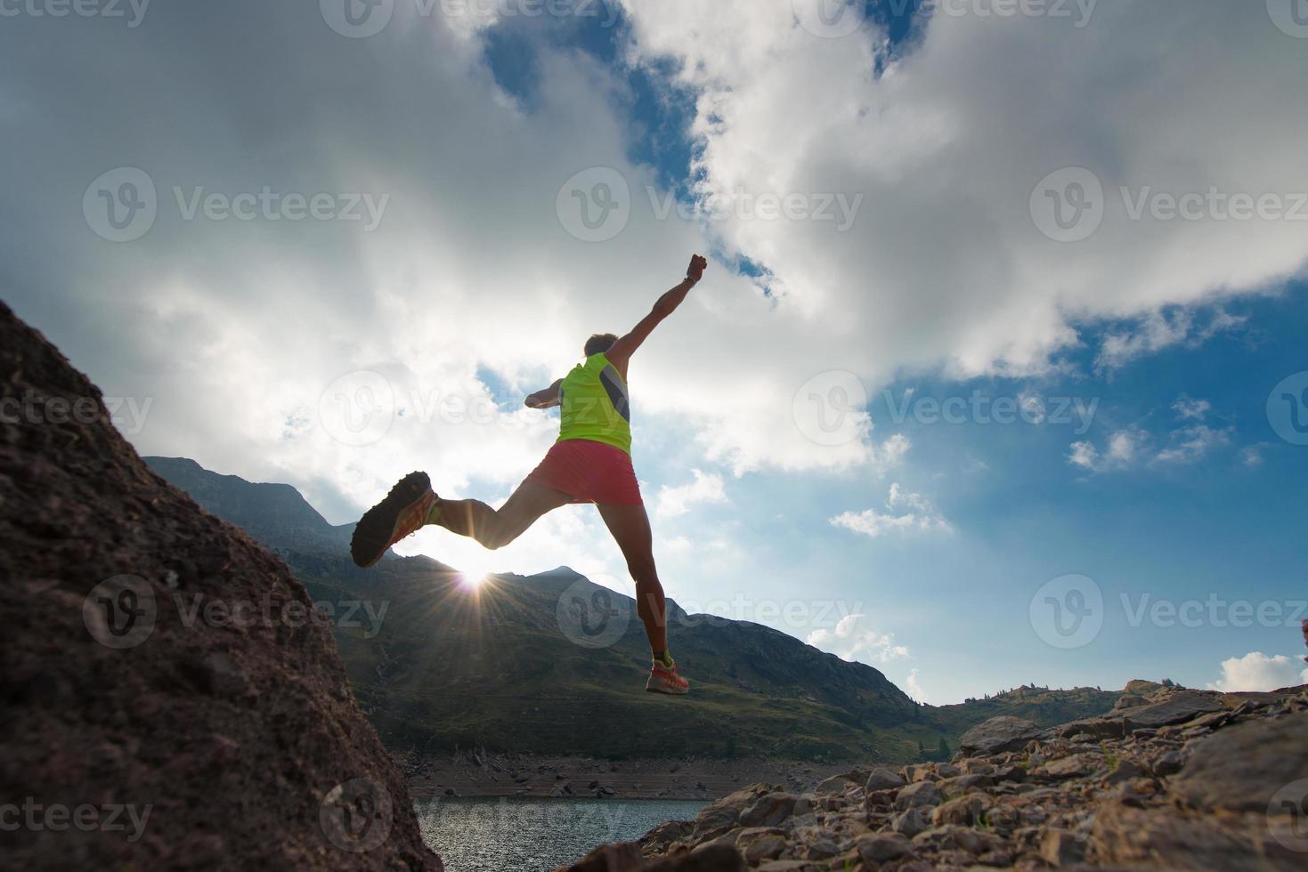 hoppar över tjejen när han springer i bergen foto