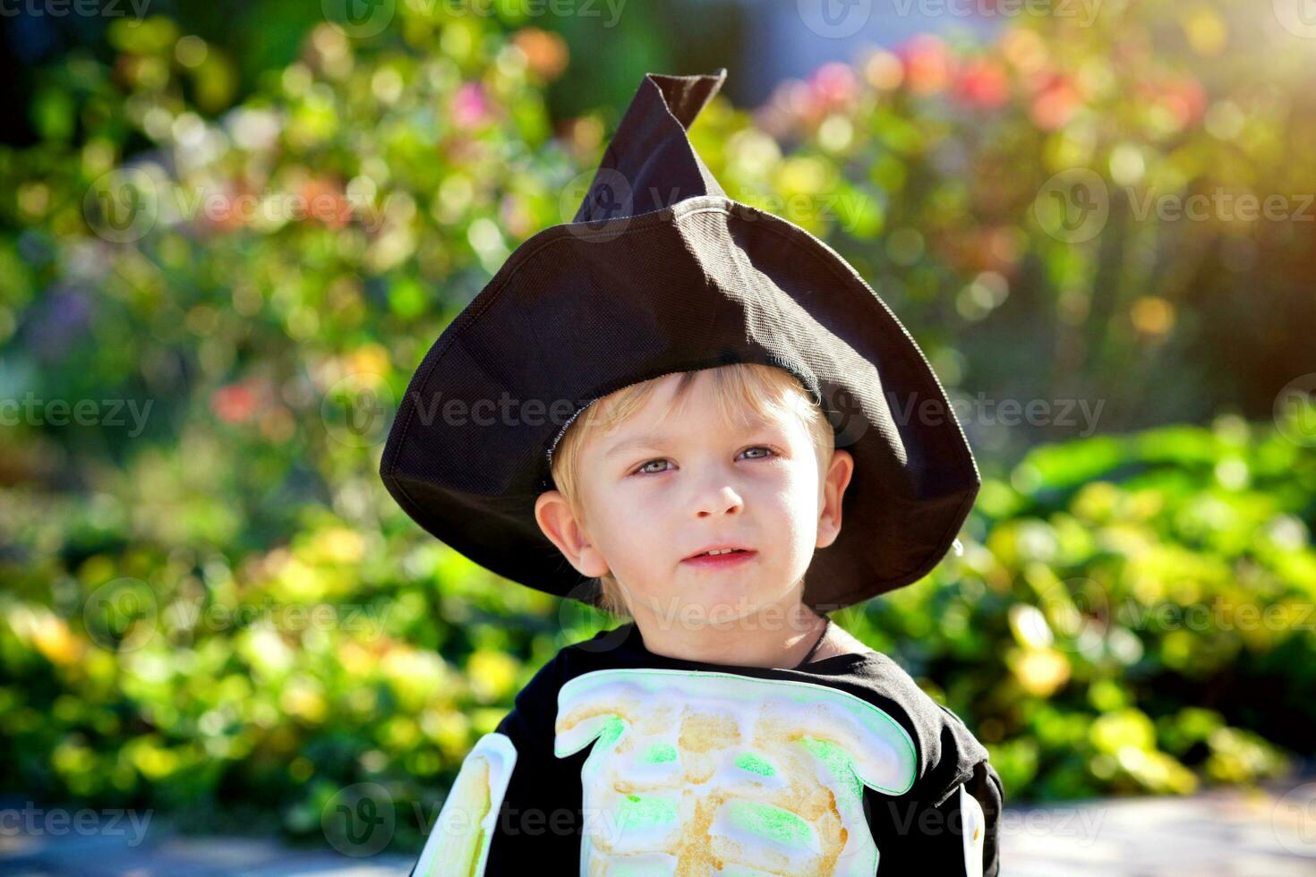 porträtt av en liten pojke bär en skelett kostym och en svart hatt. halloween Semester. foto