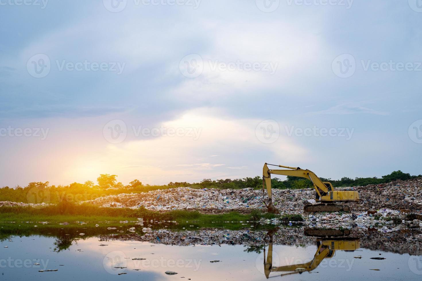 en gul traktorgrävare lyfter sopor vid avfallsavskiljningsanläggningen foto