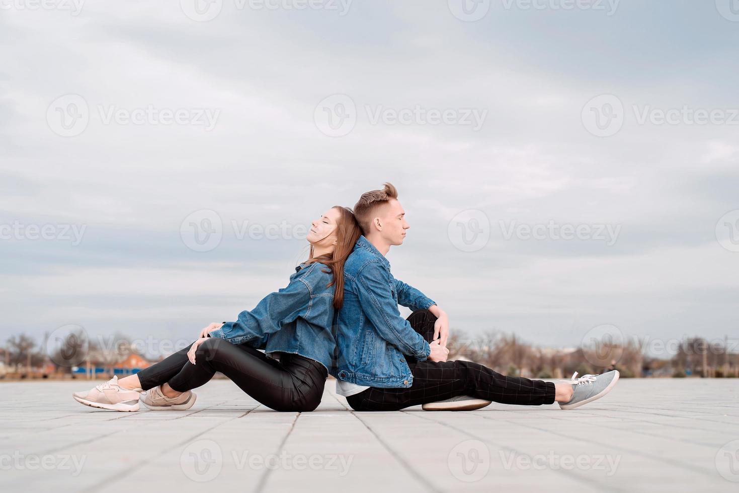 par som sitter rygg mot rygg på gatan och spenderar tid tillsammans foto