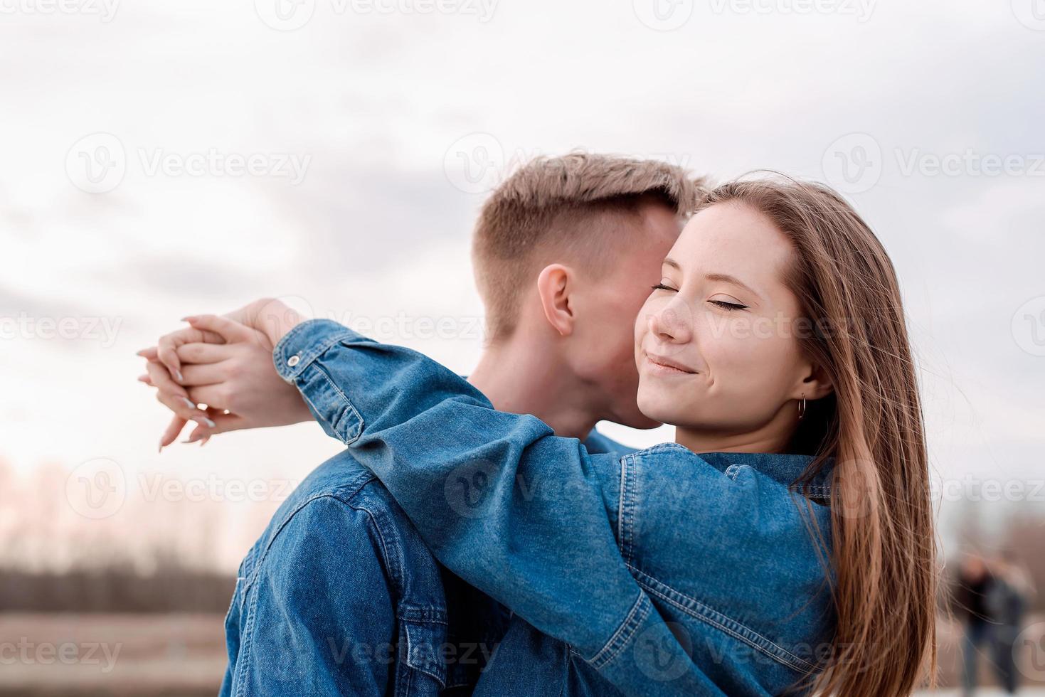 unga älskande par som omfamnar varandra utomhus i parken foto