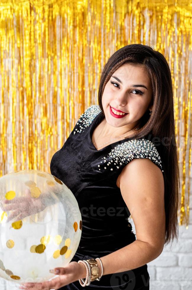 kvinna i svart festklänning som firar sin födelsedagsinnehavballong foto