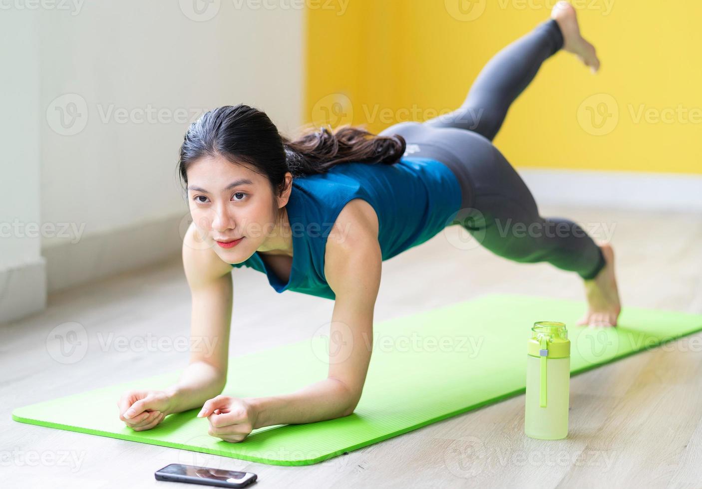 ung asiatisk tjej som gör övning på golvet ensam foto