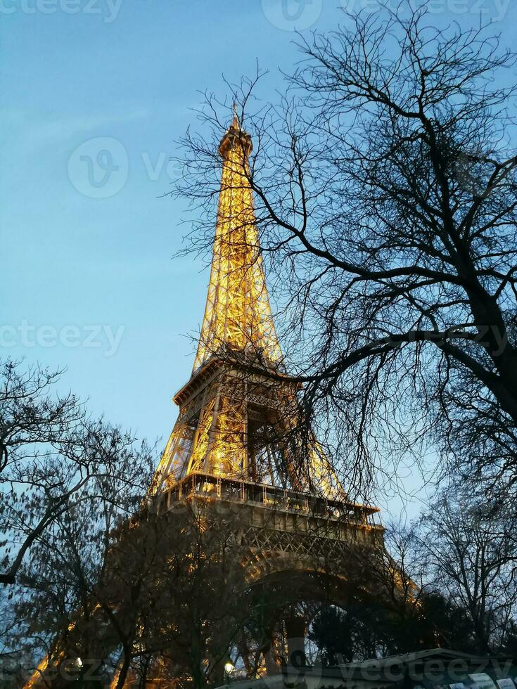 perspektiv av de eiffel torn i paris upplyst på de slutet av de dag foto