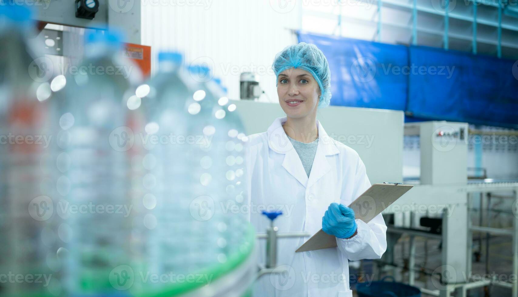 kvinna kvalitet kontrollera arbetstagare inspekterande vatten flaska på produktion linje i dricka vatten fabrik foto