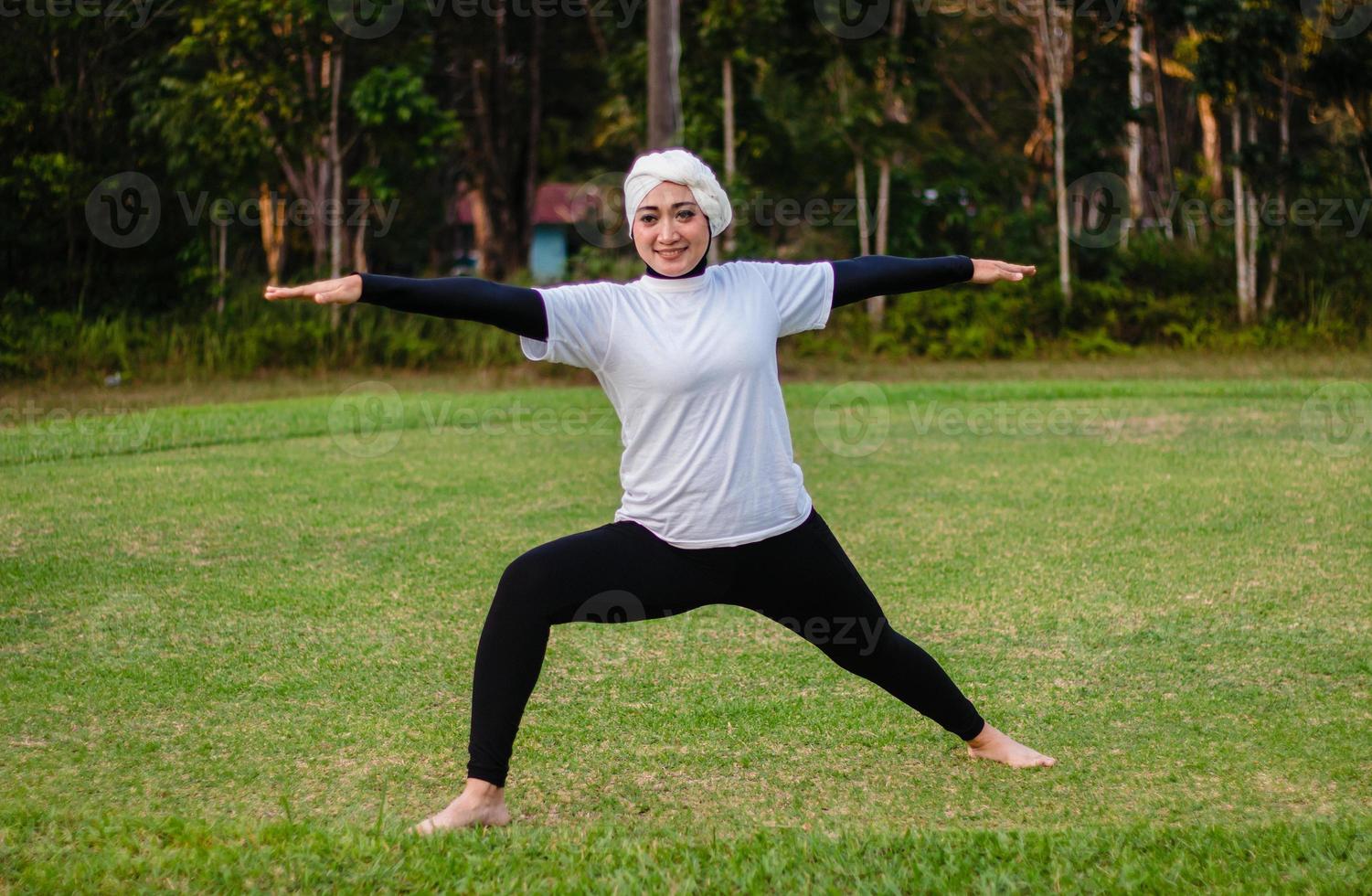 trevlig kvinna i hijab och sportkläder som gör yoga och stretching. foto