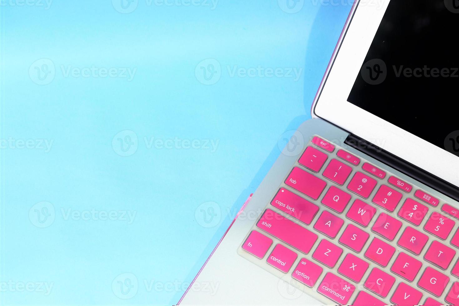 anteckningsbok med rosa tangentbord. blå bakgrund foto