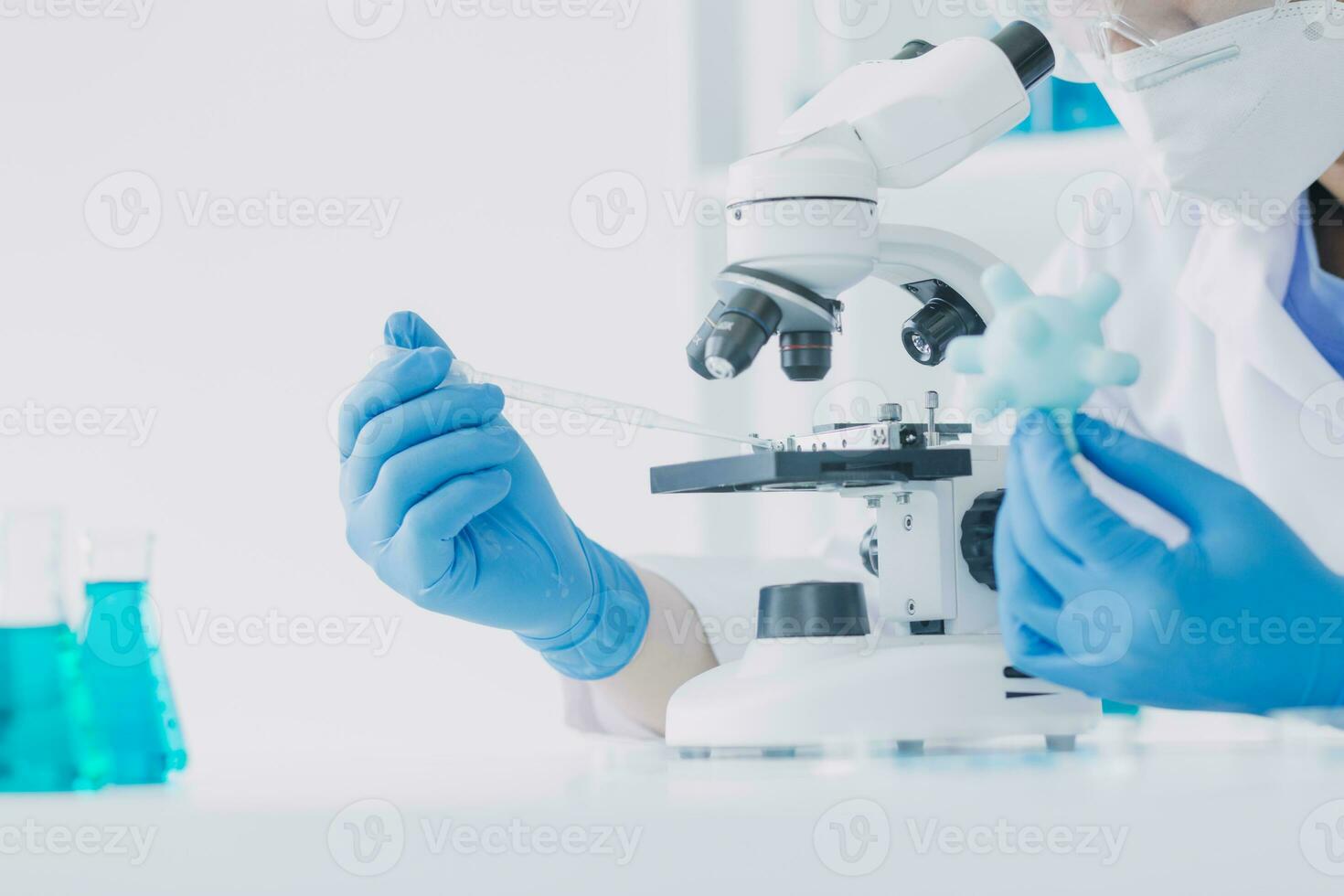 ung vetenskapsmän ledande forskning utredningar i en medicinsk laboratorium, en forskare i de förgrund är använder sig av en mikroskop foto