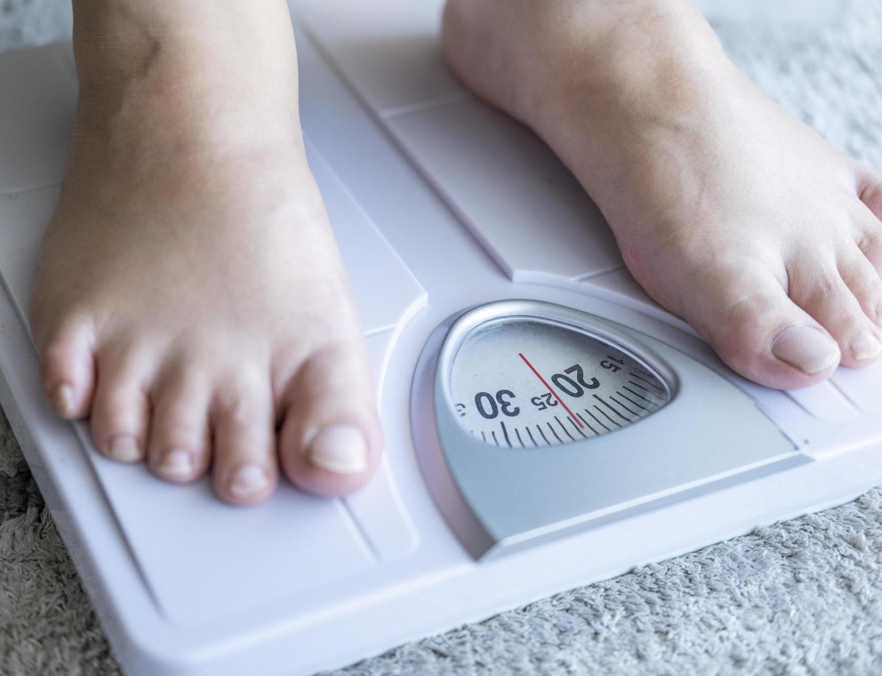 asiater fot man med kroppsvikt skalor för att mäta vikt foto