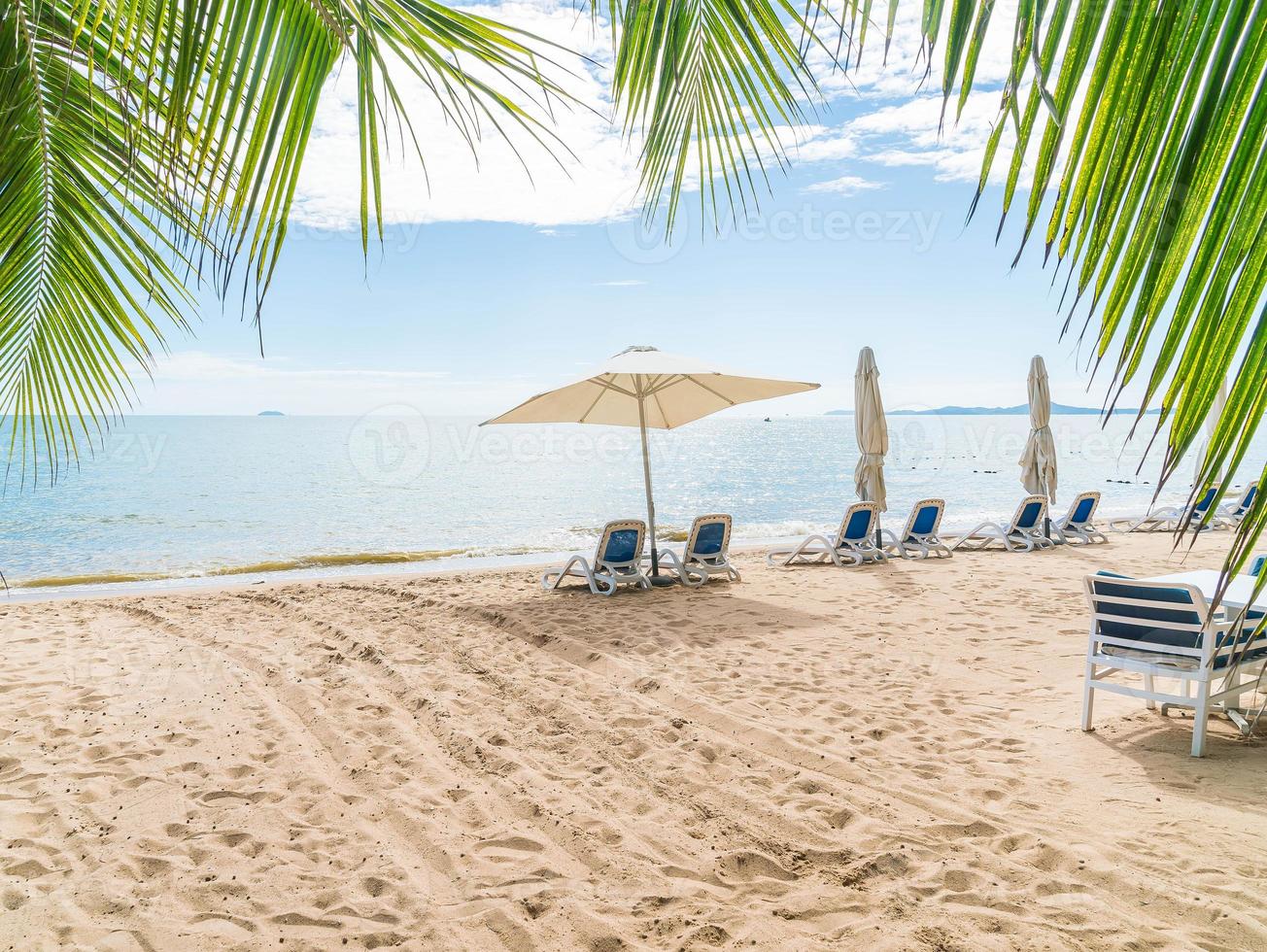 utomhus med paraply och stol på den vackra tropiska stranden och havet foto