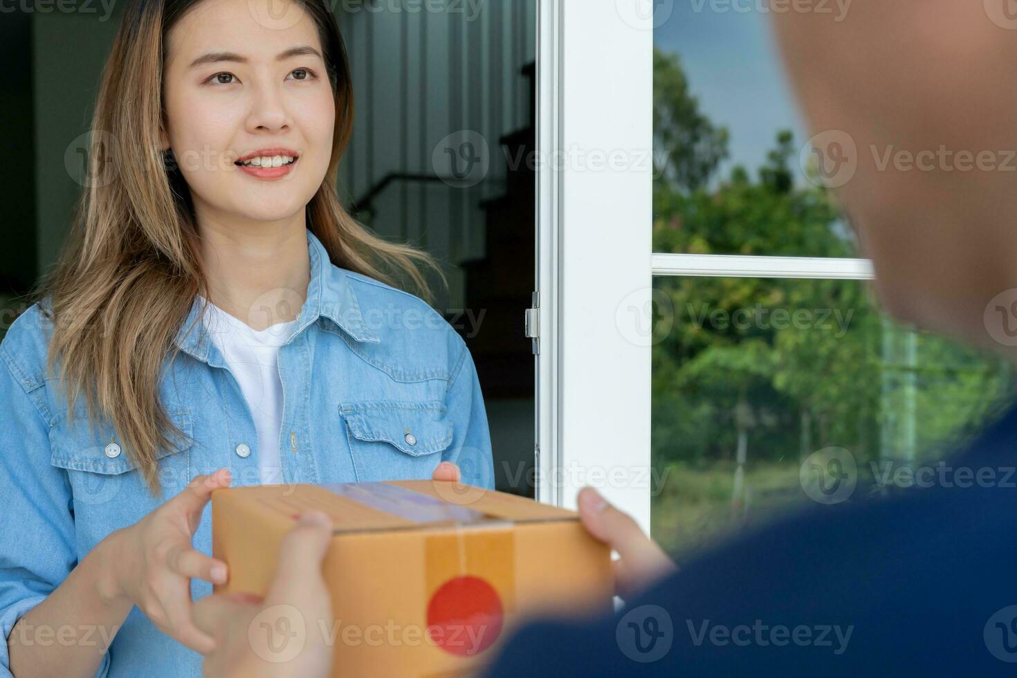 Lycklig leende kvinna mottar lådor paket från kurir i främre hus. leverans man skicka leverera uttrycka. uppkopplad handla, papper behållare, hämtmat, brevbärare, leverans service, paket foto