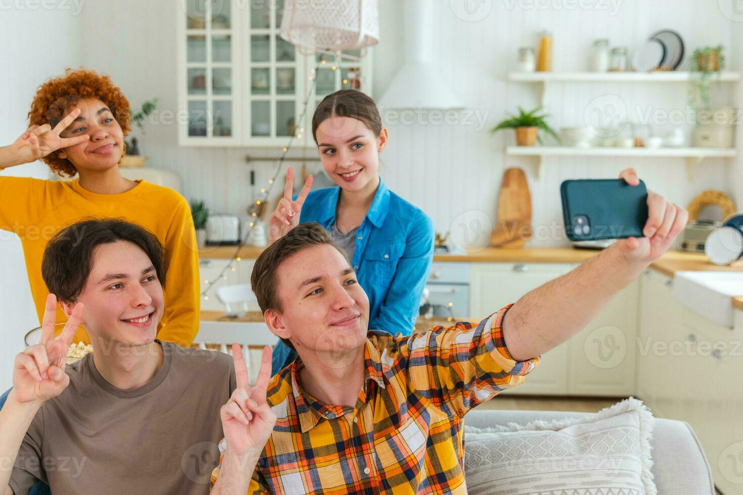 Skål skraj humör. Lycklig grupp av vänner göra selfie. man tar Foto av vänner på fest. grupp av raser ung människor tar Foto på telefon. ung människor njut av deras företag leende ha roligt.