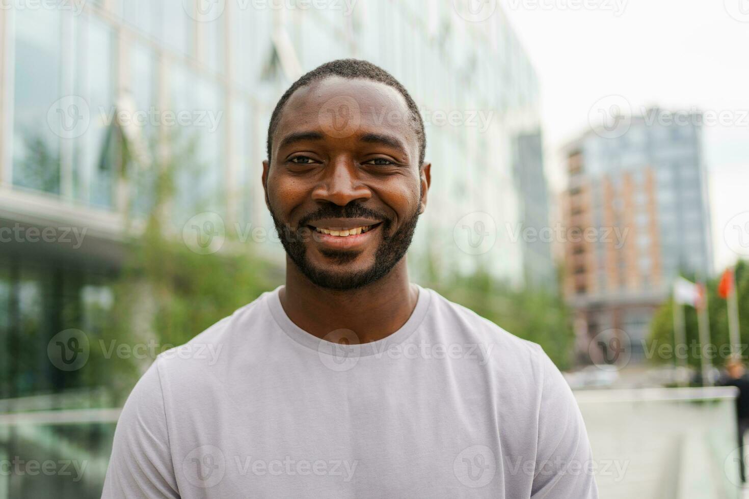 Lycklig afrikansk amerikan man leende utomhus. porträtt av ung Lycklig man på gata i stad. glad glad stilig person kille ser på kamera. frihet lycka sorglös Lycklig människor begrepp. foto