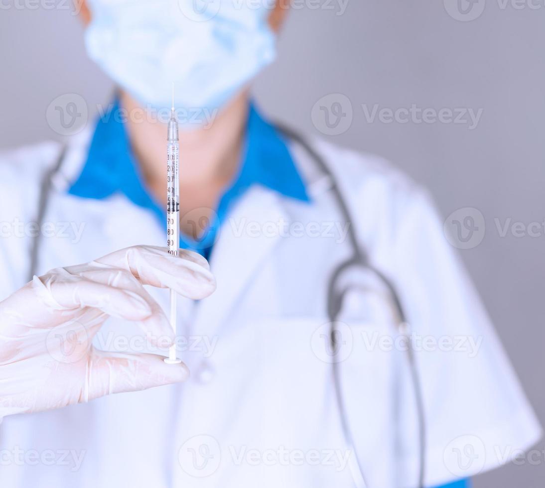 läkare som håller sprutan med medicin för att behandla covid 19 foto