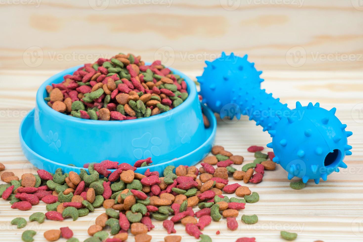 gummileksak och torrfoder för husdjur på träbakgrund foto