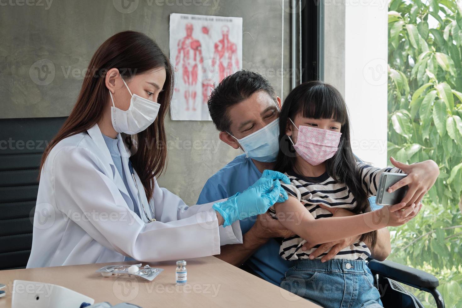 asiatisk tjej som tar en selfie medan en läkare vaccinerar. foto