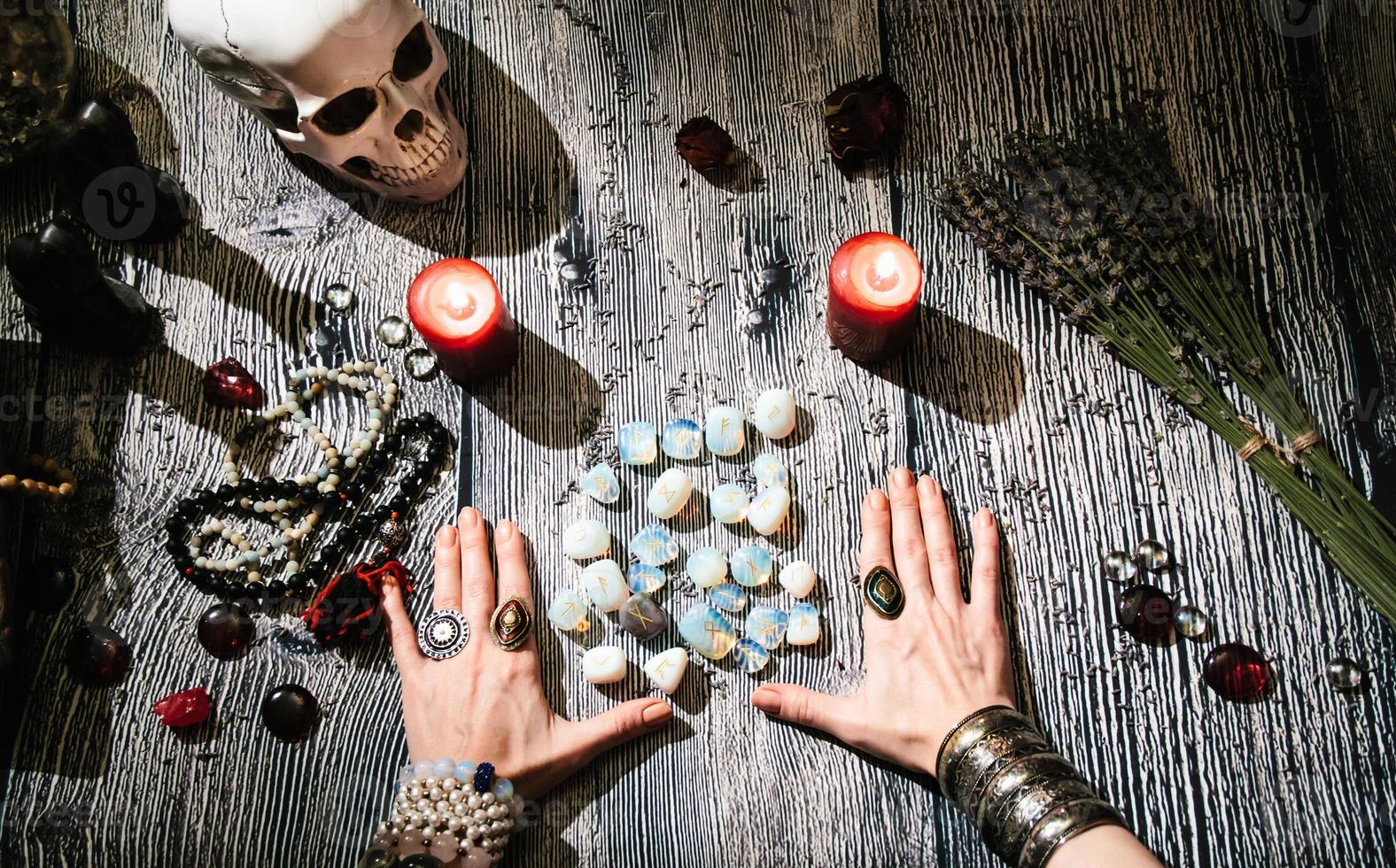 fortunetellers händer med sten runor, mystisk interiör. foto