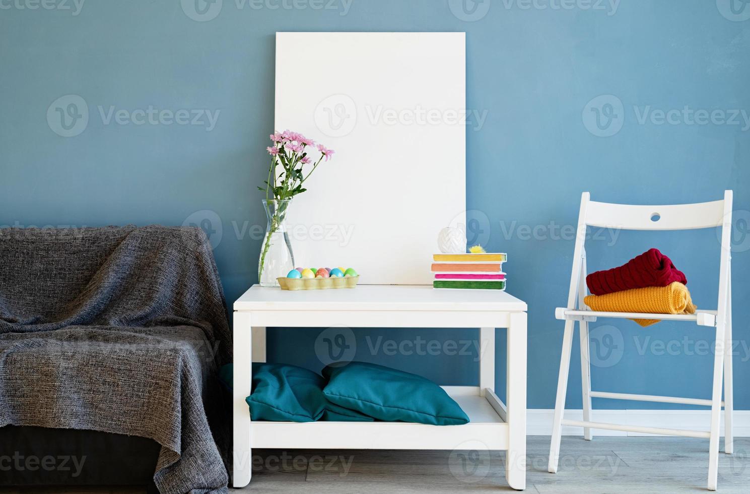 håna upp vit affisch ram på soffbord i blått rum foto