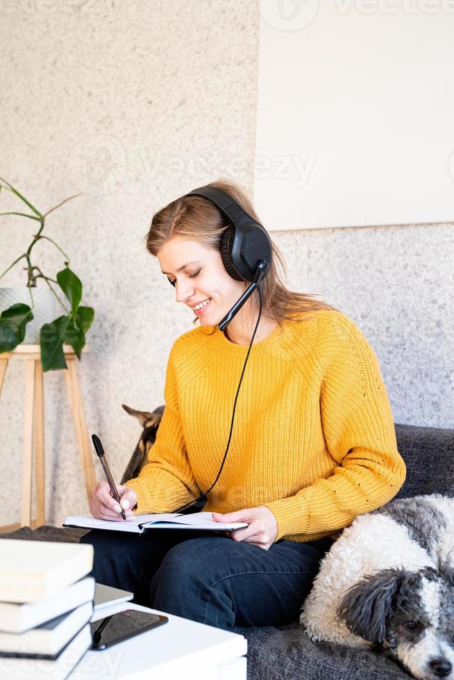 ung le kvinna i svarta hörlurar som studerar online med hjälp av bärbar dator foto