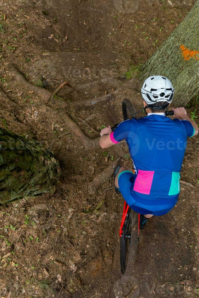 man ridning en berg cykel genom en trädbevuxen område på sommar dag. foto