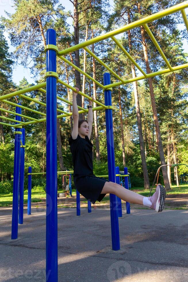 porträtt av skön tonåring ålder atletisk flicka Träning utomhus på öppen luft Gym på sommar solig dag foto