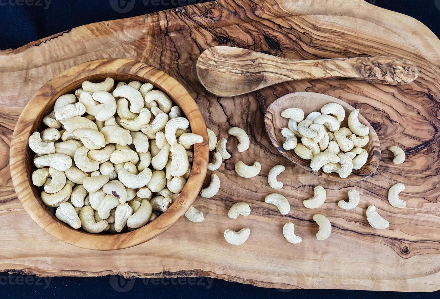 en hög med cashewnötter på olivträ foto