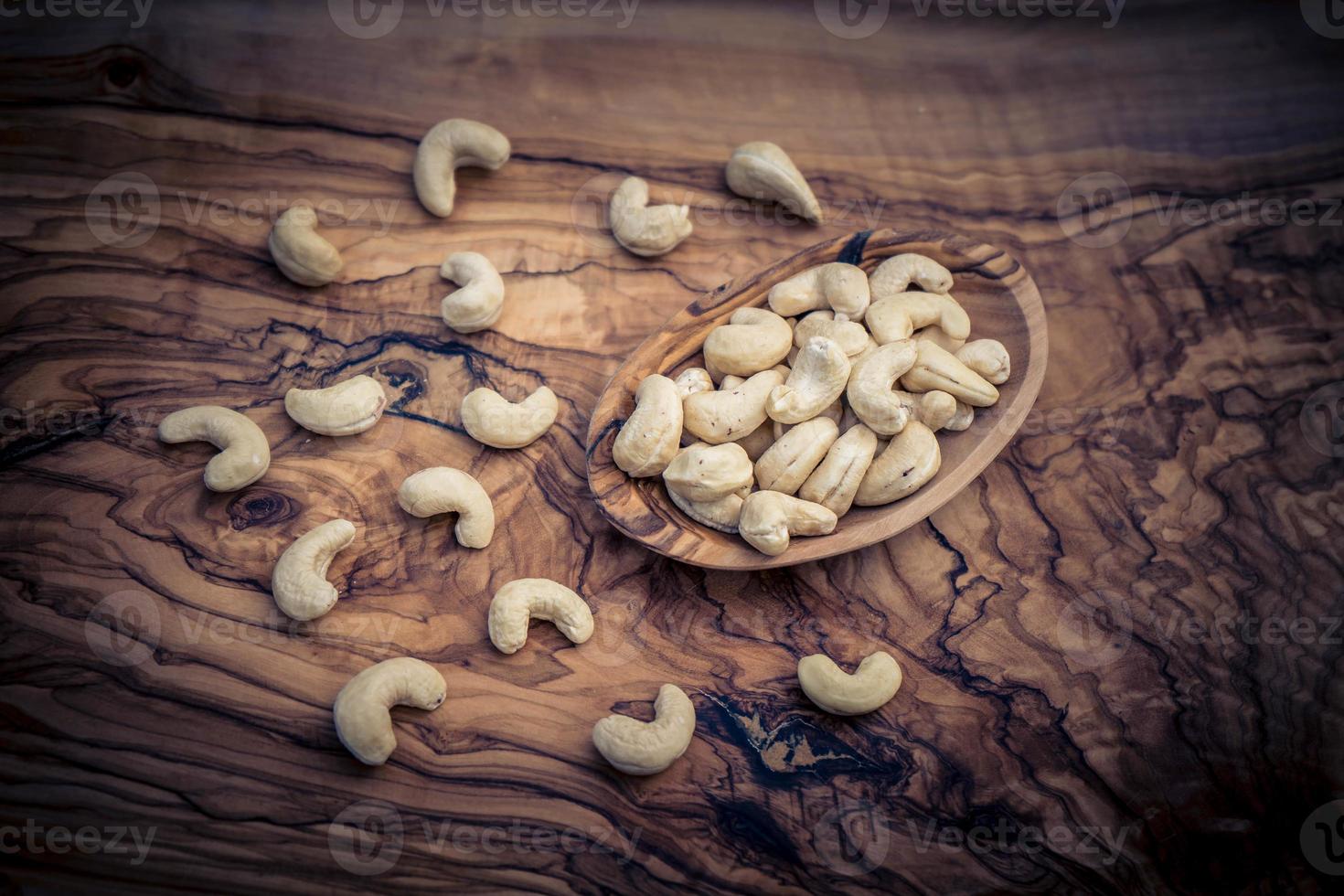 en hög med cashewnötter på olivträ foto