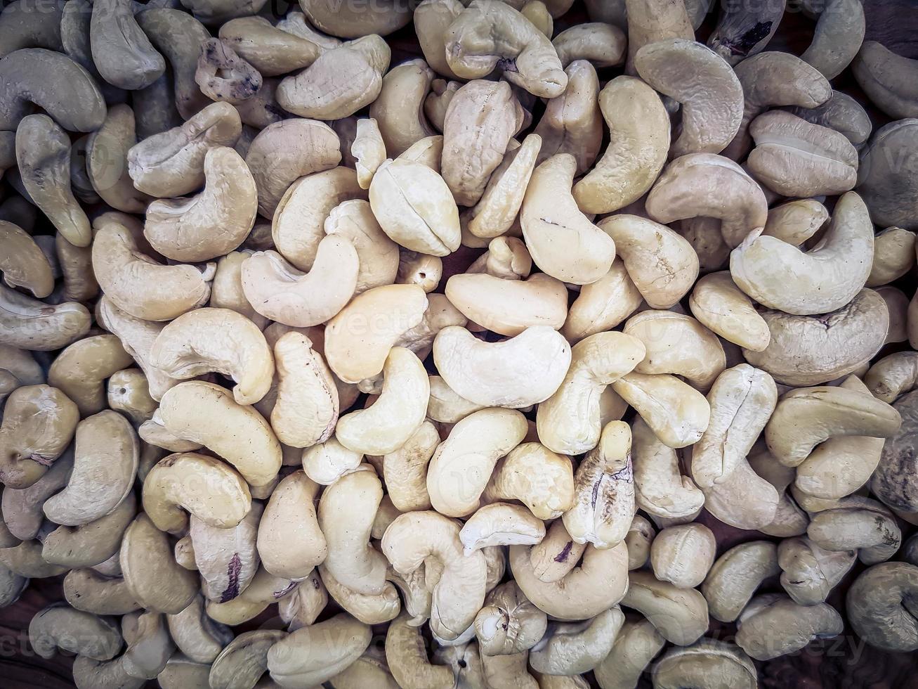 en hög med cashewnötter på olivträ foto