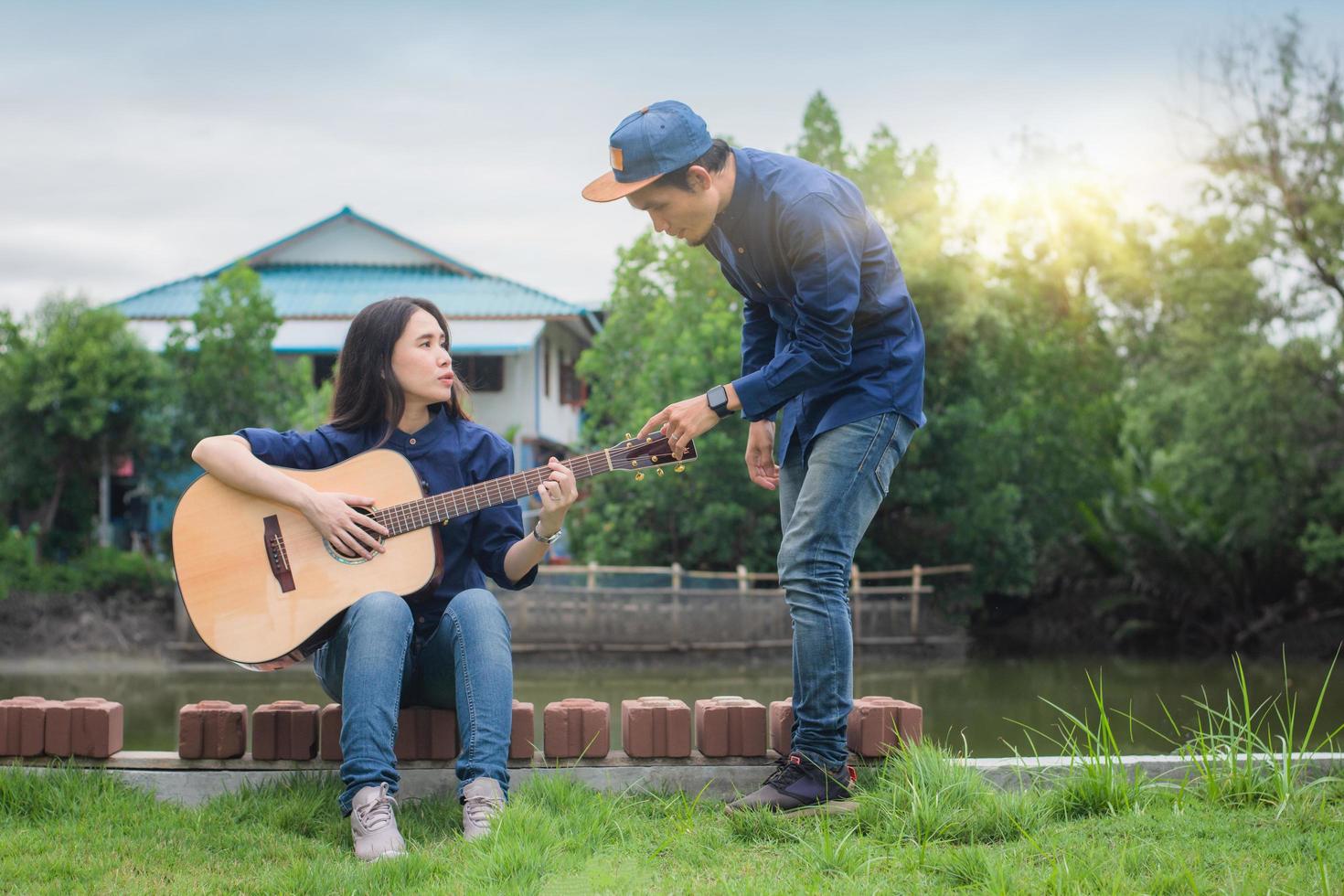 två personer vänner spelar gitarr vila på sommaren glad i semester foto