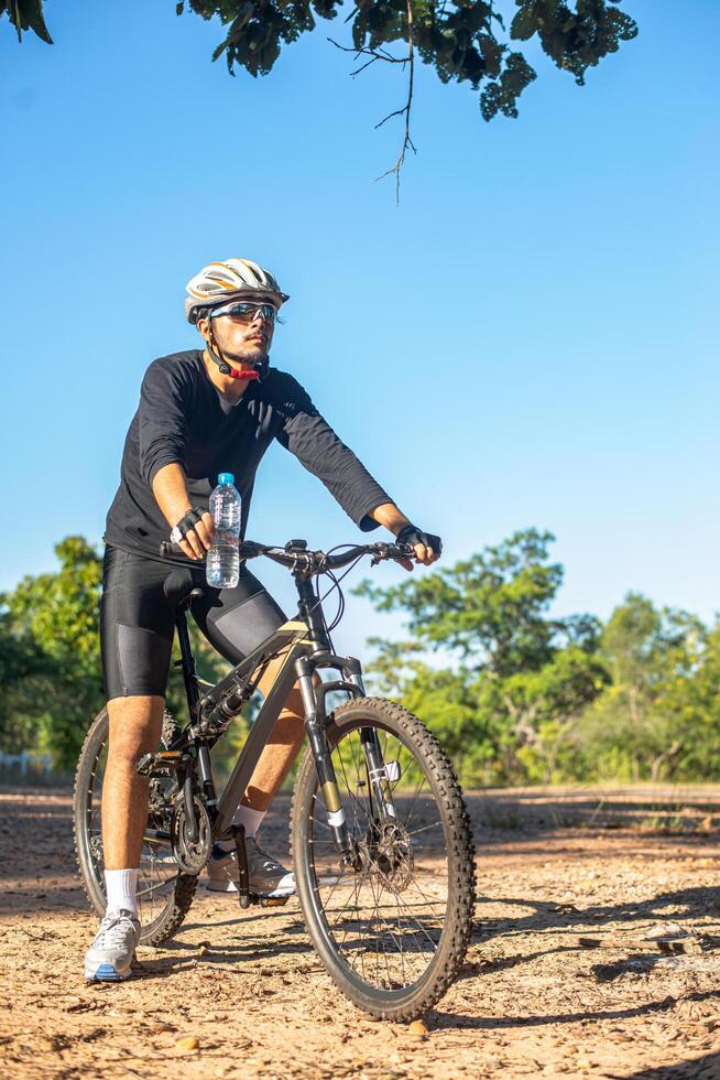 bergcyklister sitter på cyklar och bär vattenflaskor foto