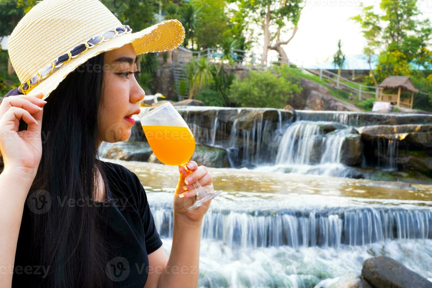 stående kvinnahand som håller nypressad apelsinjuice i glas foto