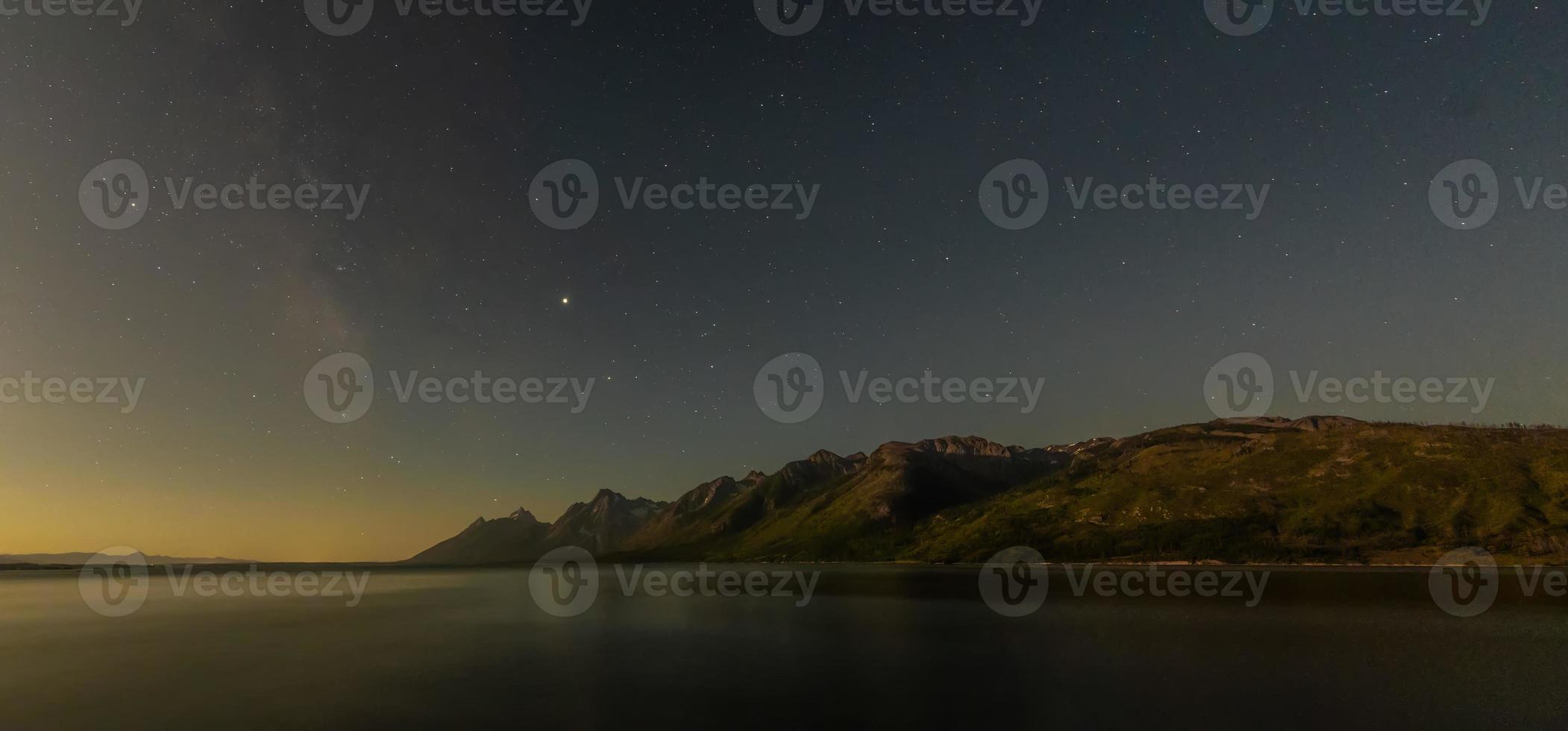 gryningen bryter över stjärnhimmel och tetons intervall foto