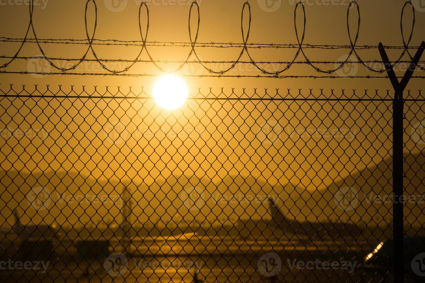 säkerhetsstaket runt den internationella flygplatsen vid soluppgång foto