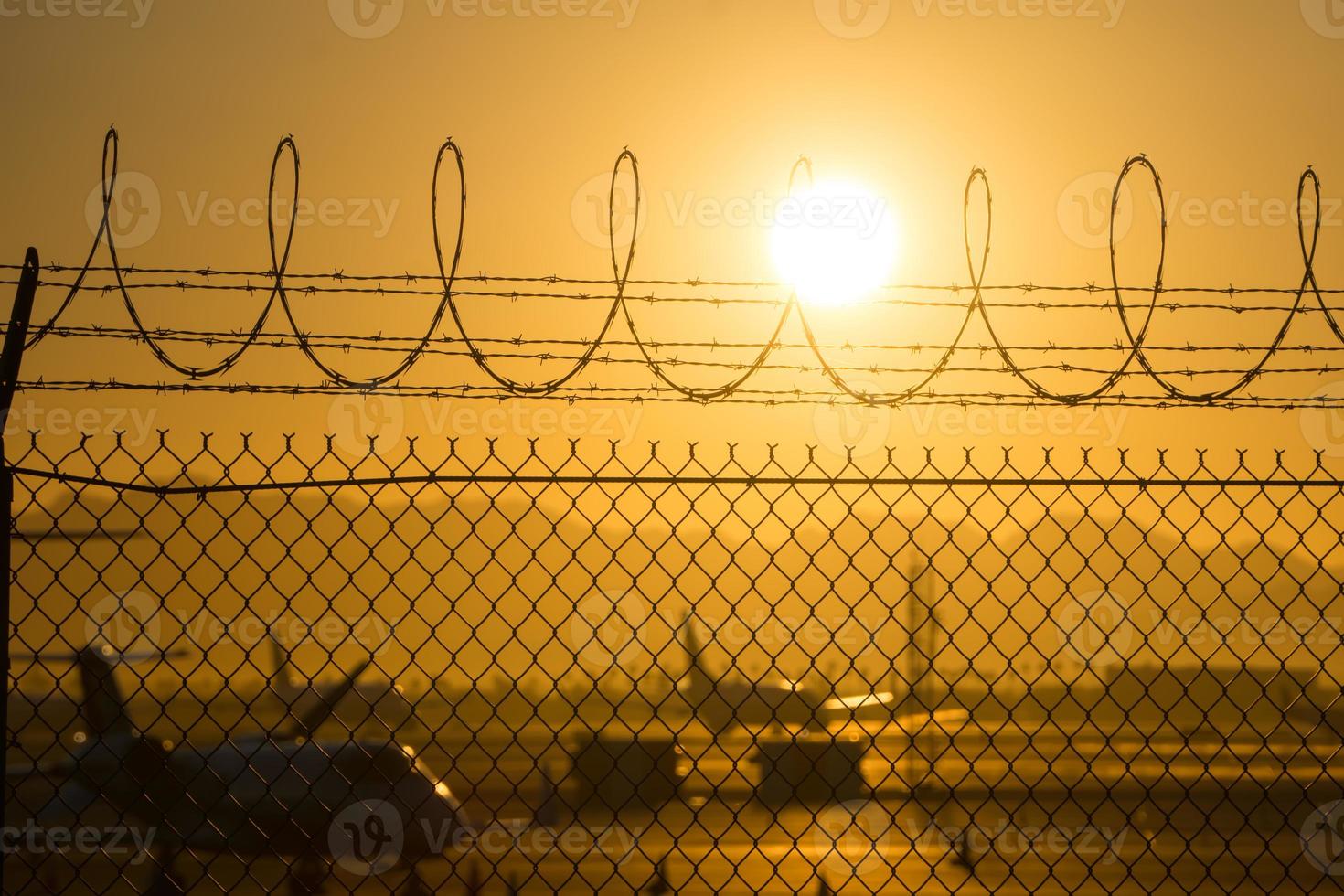 säkerhetsstaket runt den internationella flygplatsen vid soluppgång foto