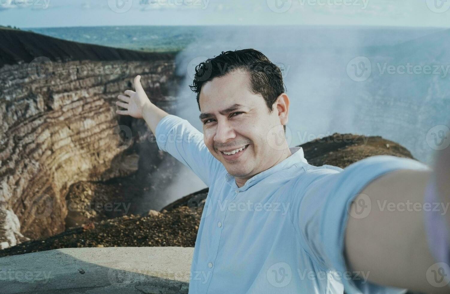 turist tar en selfie på en synpunkt. stilig turist tar en selfie på semester. äventyrlig man tar en selfie på en synpunkt. stänga upp av person tar ett äventyr selfie foto