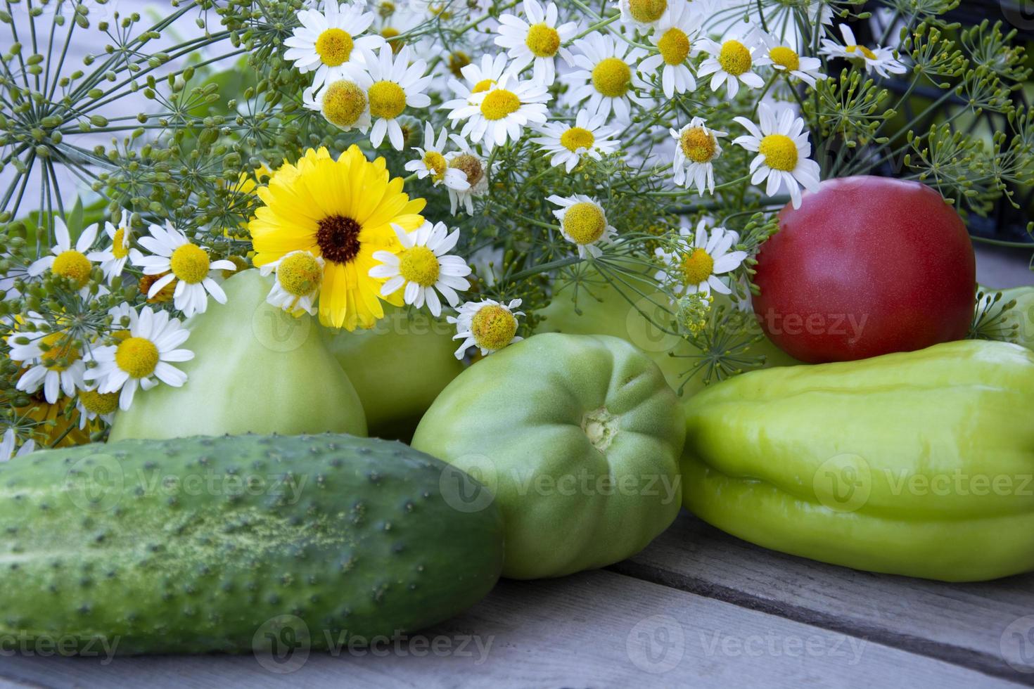 grönsaker och en bukett med vilda blommor närbild. Färska grönsaker foto