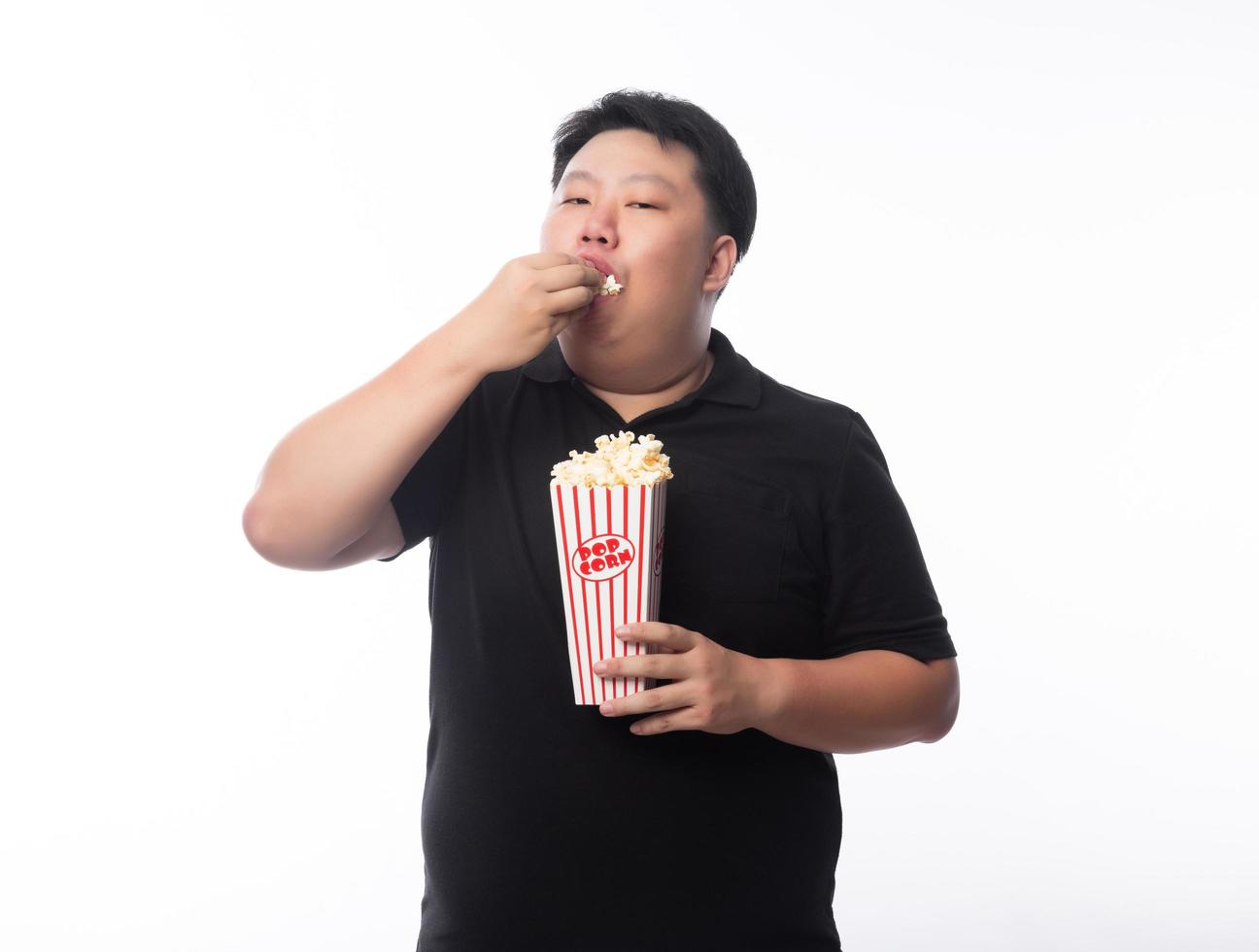 asiatisk man som äter popcorn på vit bakgrund foto