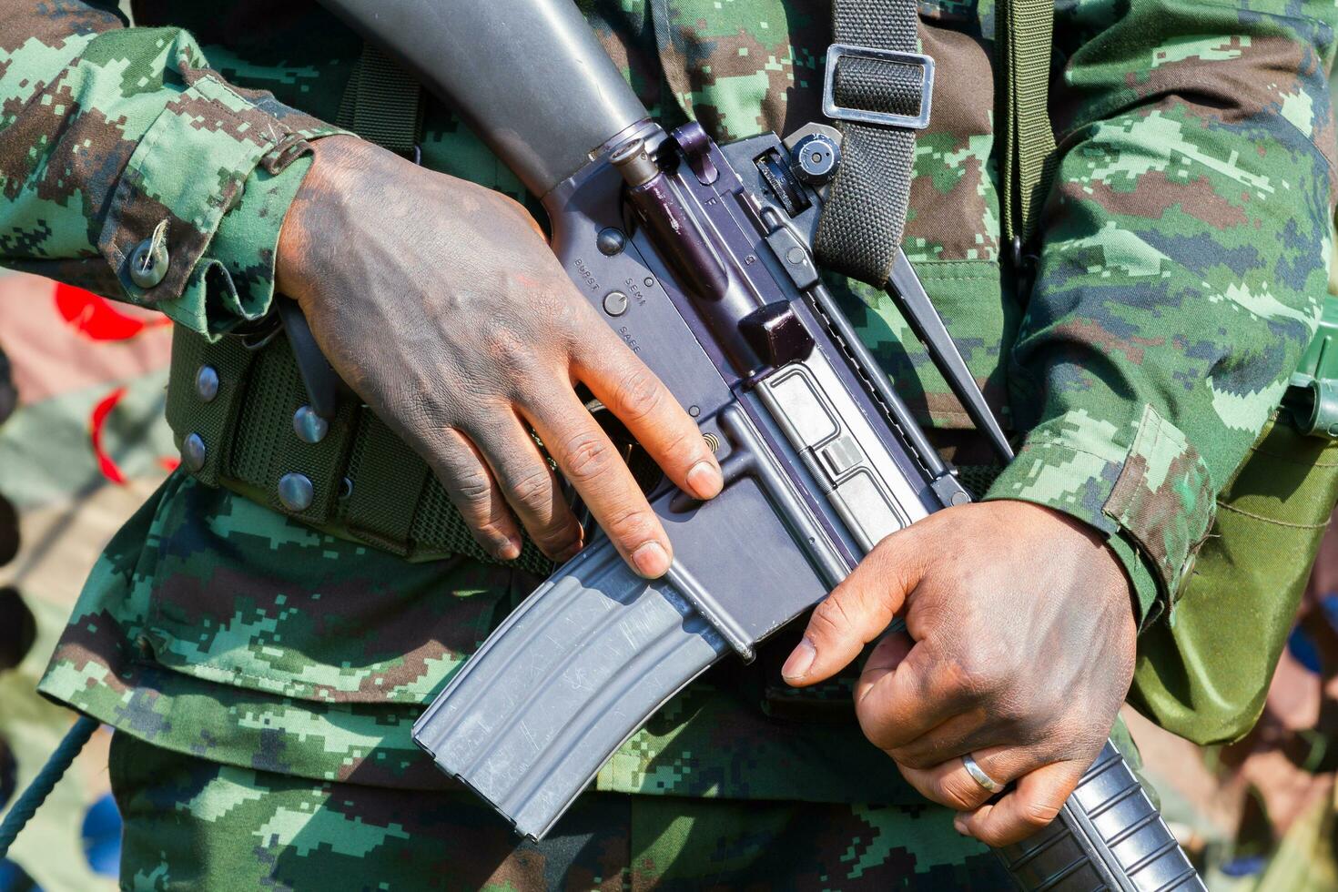 närbild manliga soldat händer som håller kulsprutan foto