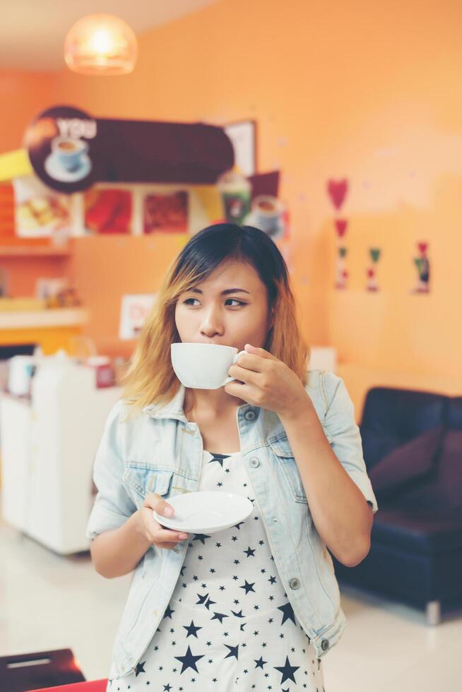 ung vacker kvinna dricka varmt cappuccino kaffe på café. foto