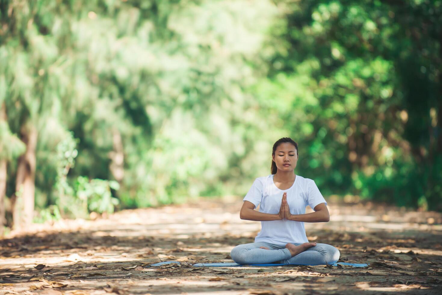 ung asiatisk kvinna som gör yoga på morgonen i parken. hälsosam foto