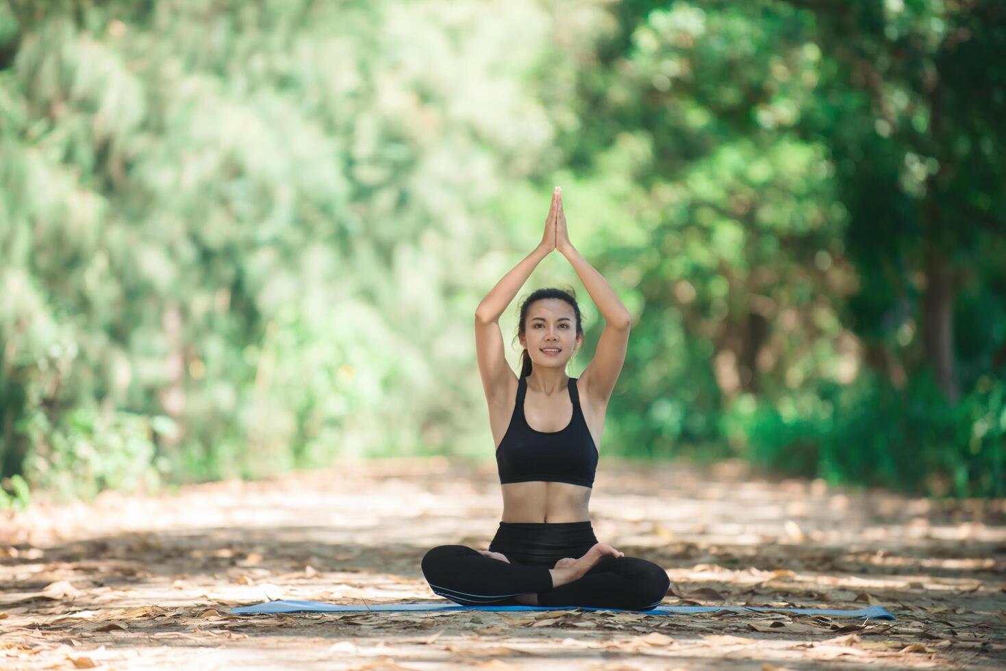 ung asiatisk kvinna som gör yoga på morgonen i parken. hälsosam foto