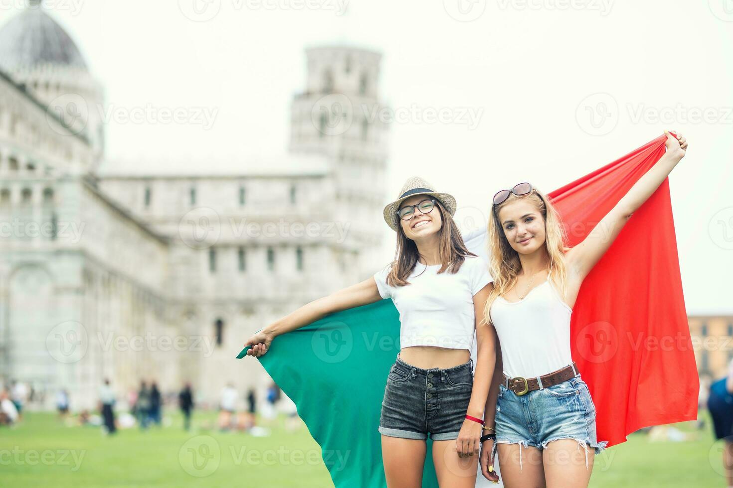 ung tonåring flickor resande med italiensk flagga innan de historisk torn i stad pisa - Italien foto