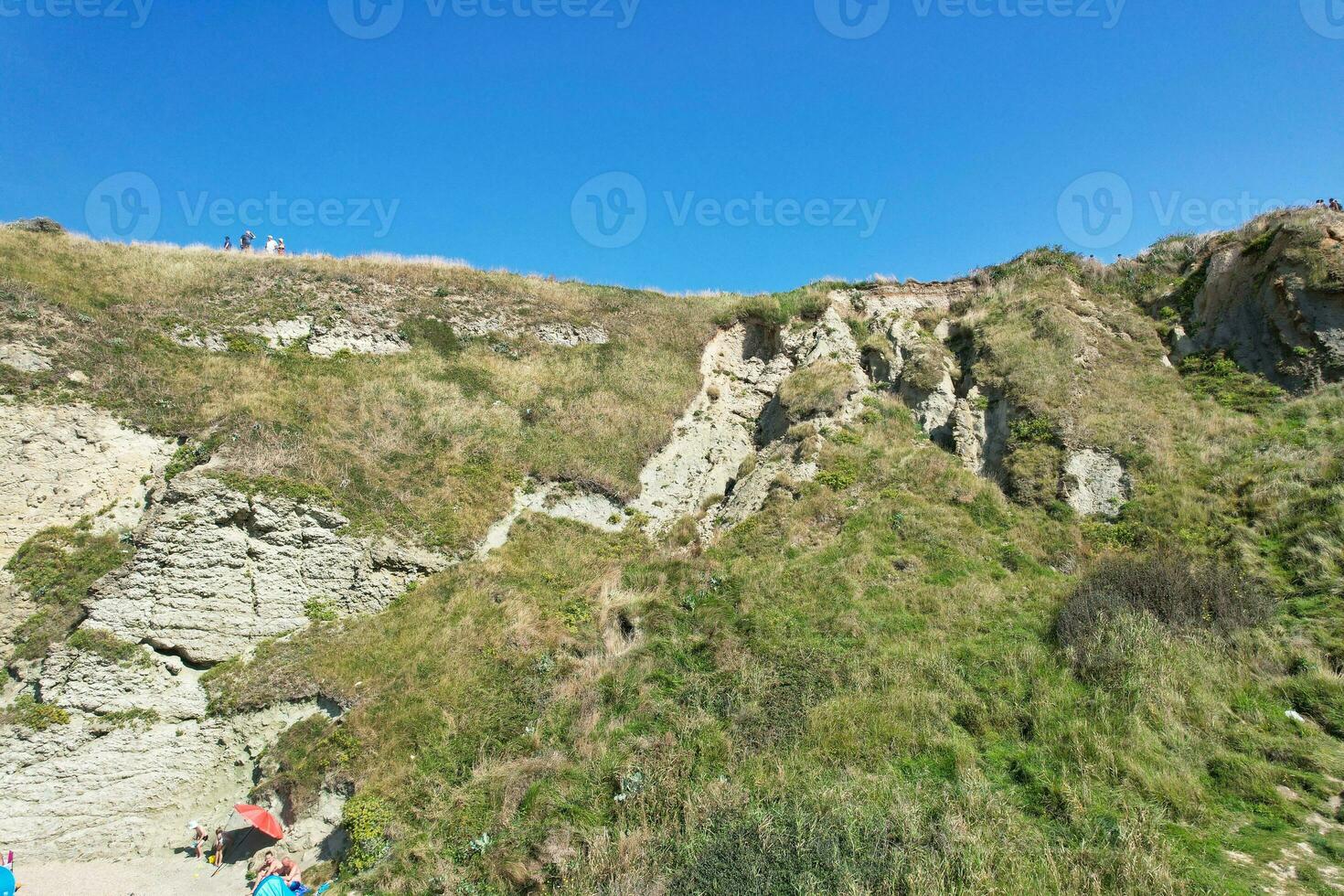 hög vinkel se av människor är närmar sig till durdle dörr strand som är mest känd turist attraktion plats genom gående distans över landskap och kullar. fångad på september 9:e, 2023 foto