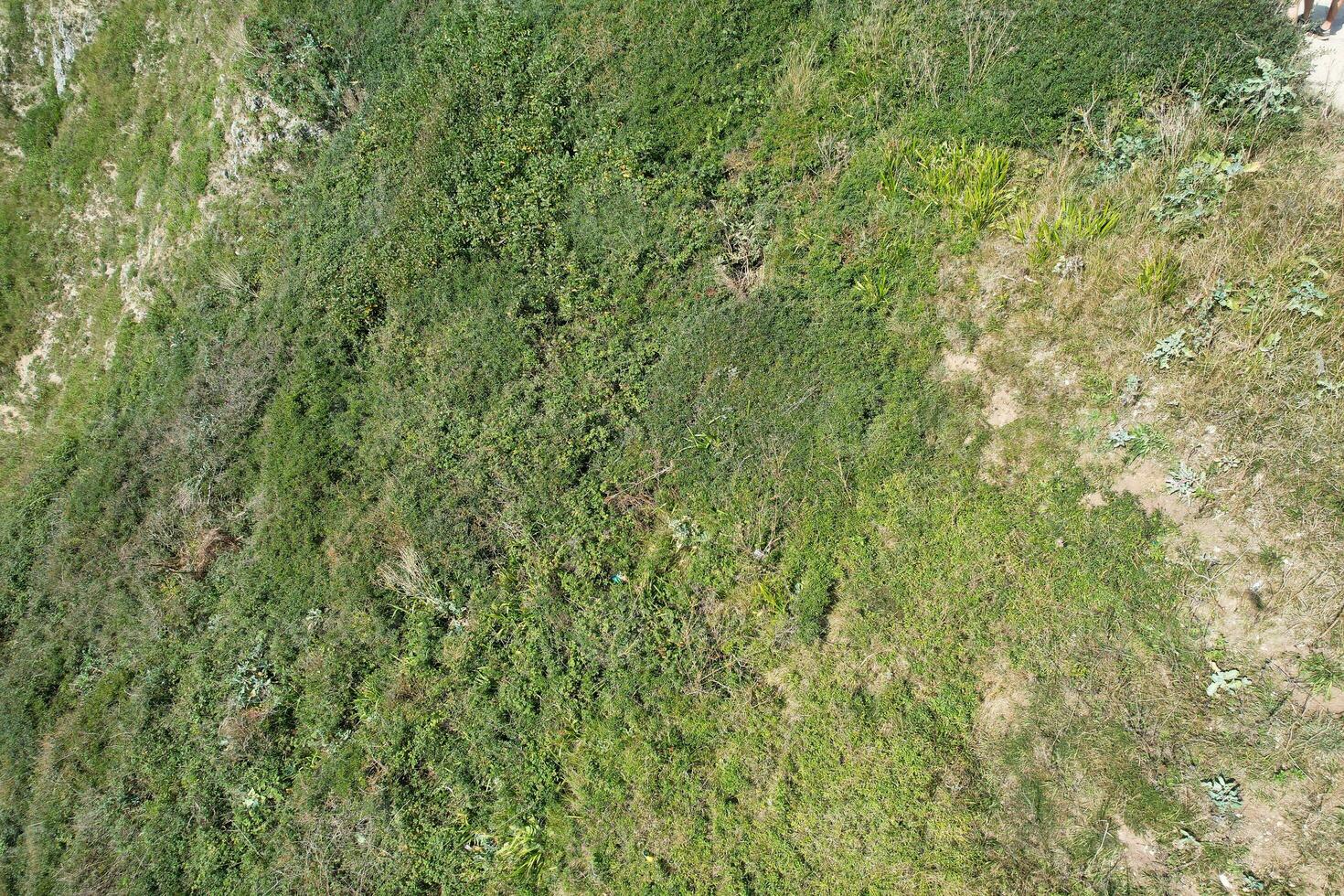 hög vinkel se av människor är närmar sig till durdle dörr strand som är mest känd turist attraktion plats genom gående distans över landskap och kullar. fångad på september 9:e, 2023 foto