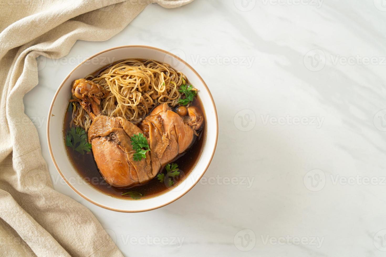 nudlar med bräserad kyckling i brun soppa foto
