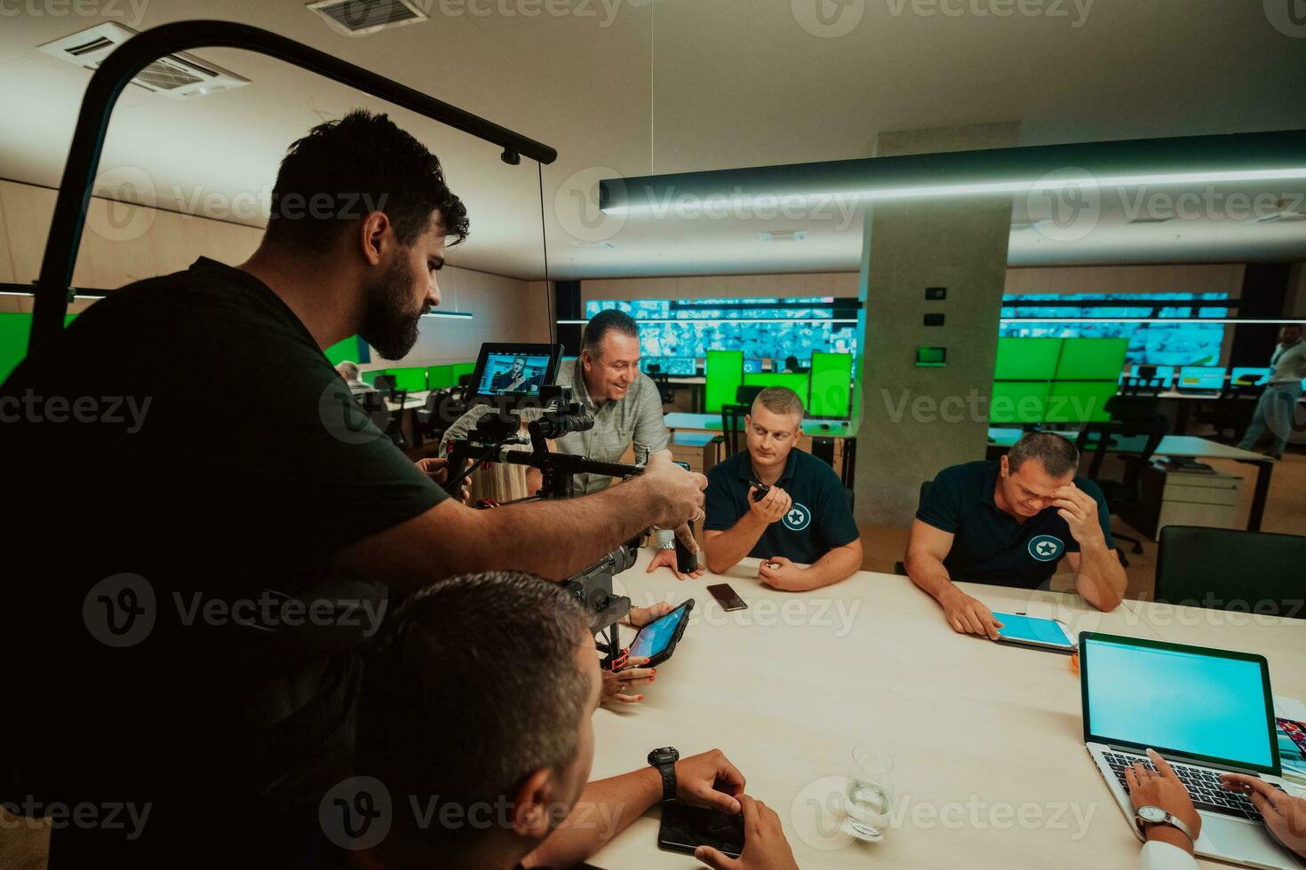 professionell videographer med gimball video slr inspelning video av säkerhet data Centrum operatörer medan arbetssätt i en cCTV övervakning rum ser på flera olika monitorer team arbetssätt på de systemet lura foto