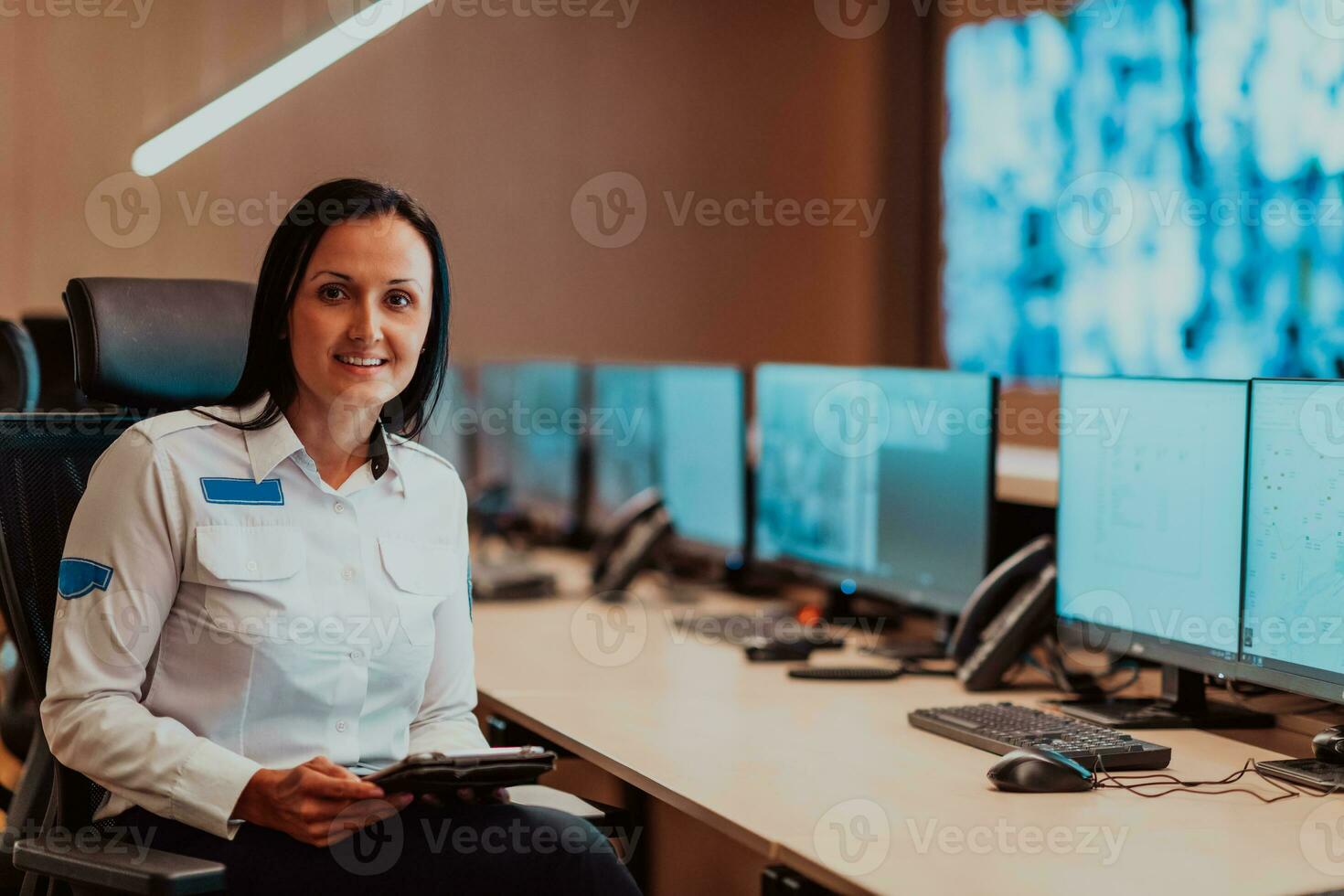 kvinna säkerhet operatör arbetssätt i en data systemet kontrollera rum kontor teknisk operatör arbetssätt på arbetsstation med flera olika skärmar, säkerhet vakt arbetssätt på flera olika monitorer foto