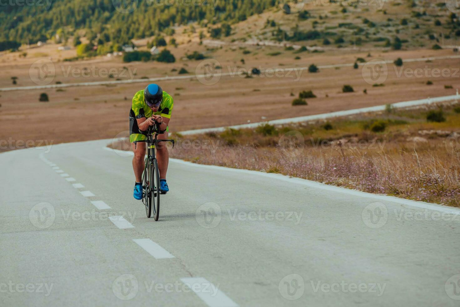 full längd porträtt av ett aktiva triathlete i sportkläder och med en skyddande hjälm ridning en cykel. selektiv fokus foto