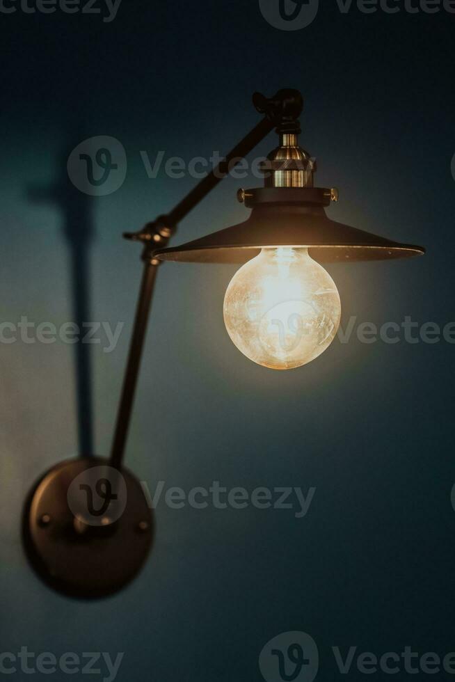 gammal ljus Glödlampa på en modern blå vägg. selektiv fokus foto