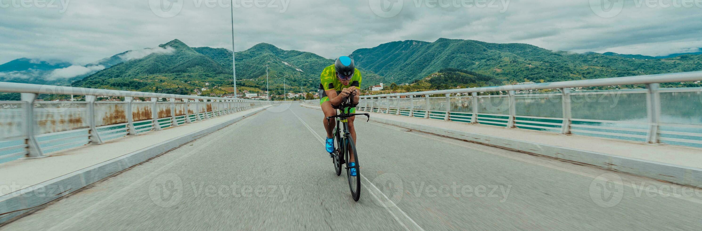 full längd porträtt av ett aktiva triathlete i sportkläder och med en skyddande hjälm ridning en cykel. selektiv fokus foto